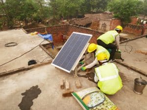 Das Solarmodul für das Microgrid wird am Gestell angebracht, ausgerichtet und mit einem einfachen Fundament am Hausdach befestigt.